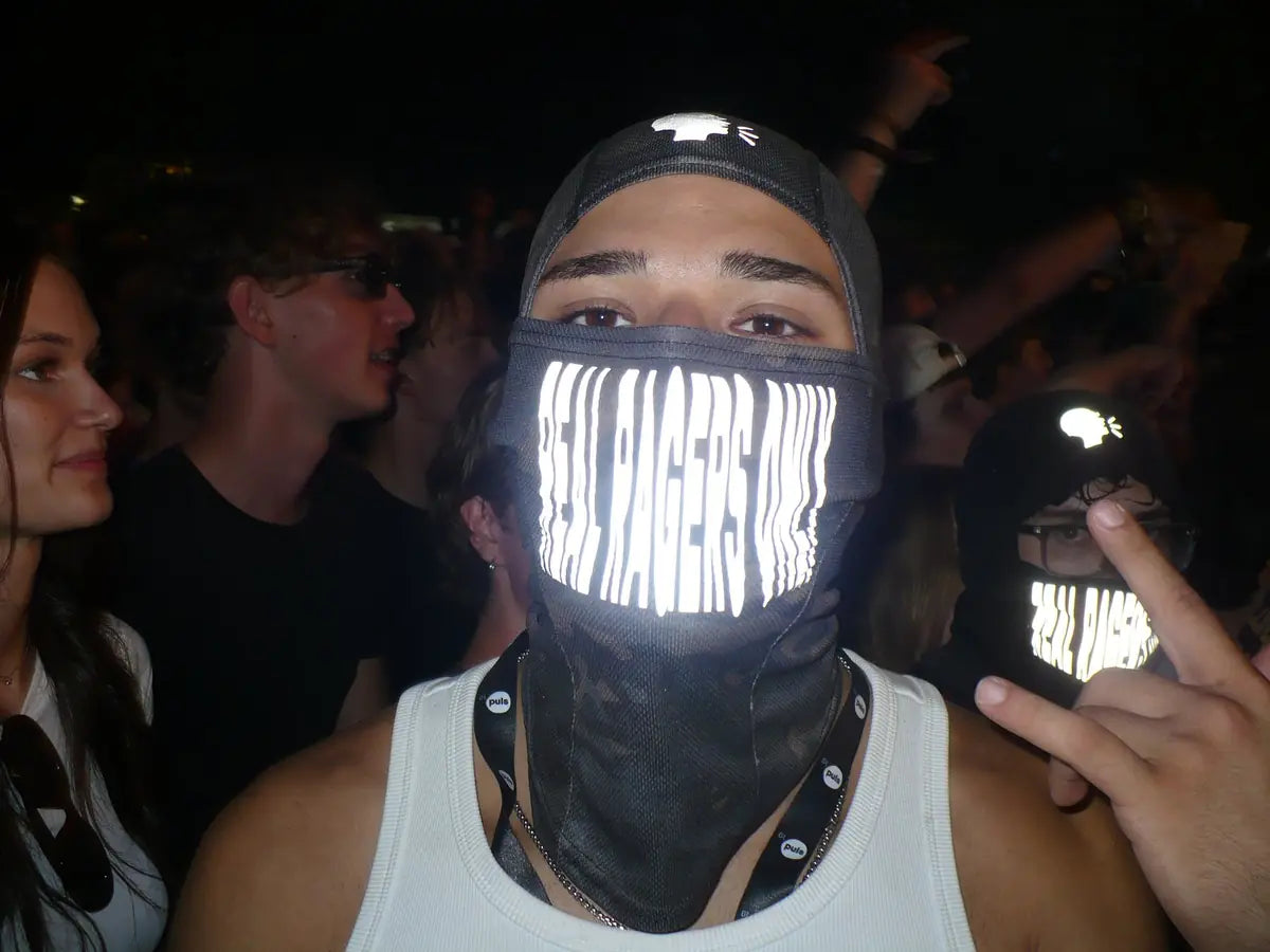 Rager mit RRO-Maske nachts in der Crowd, der Print leuchtet