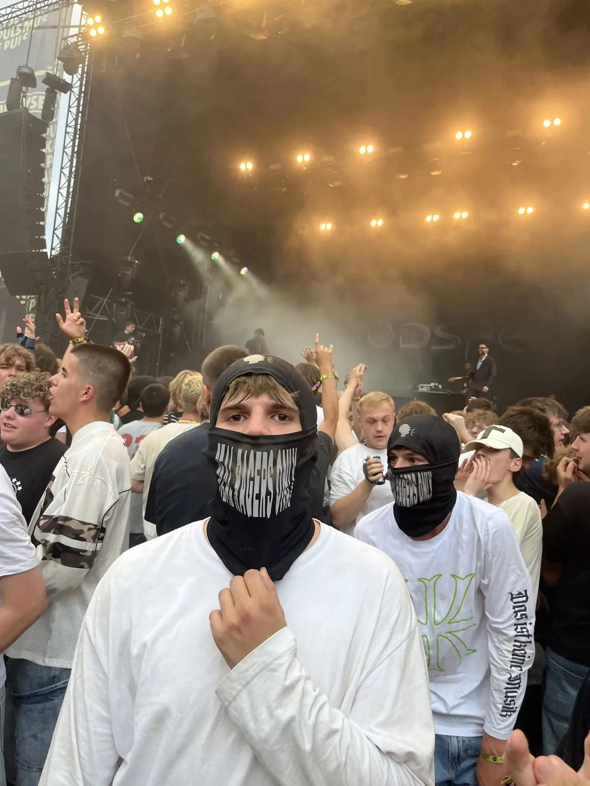 Rager mit schwarzer RRO-Maske vor der Festivalbühne
