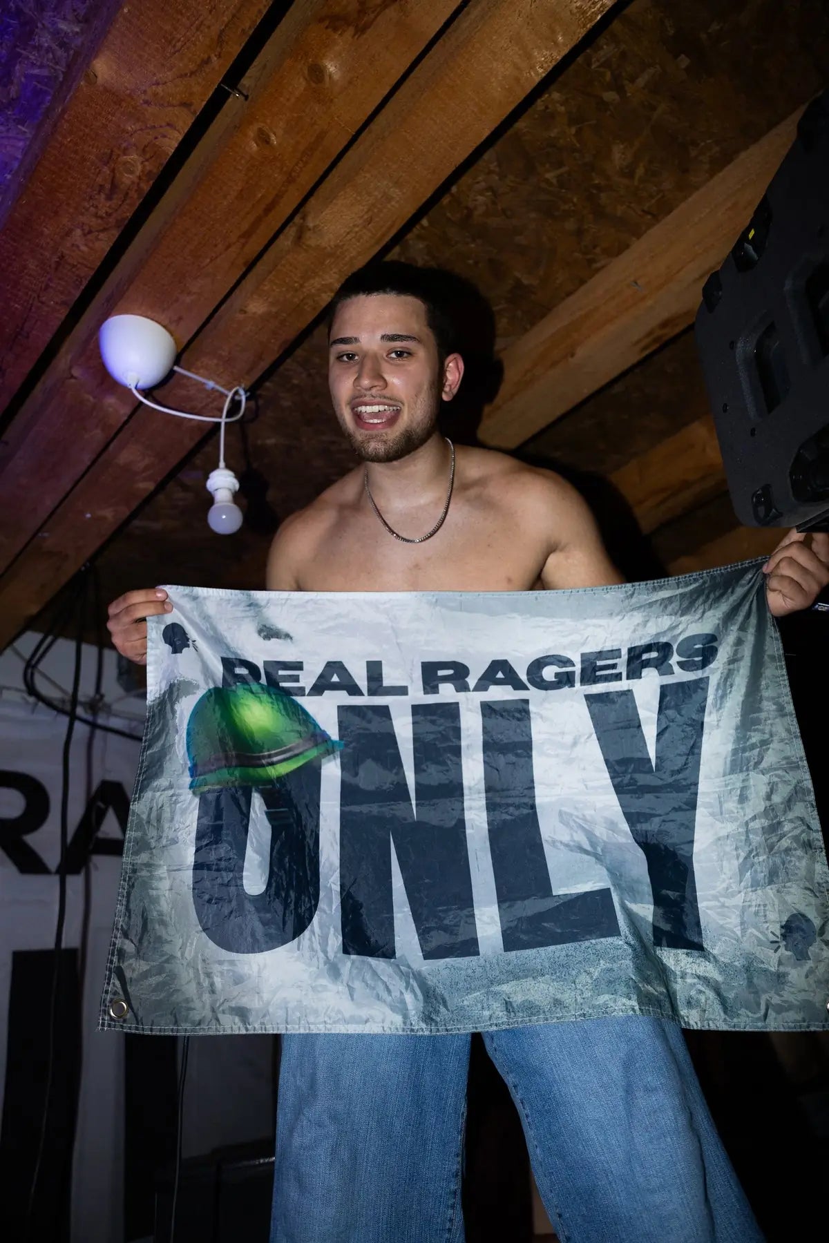 Rager hält die weiße RRO-Flagge im Club hoch