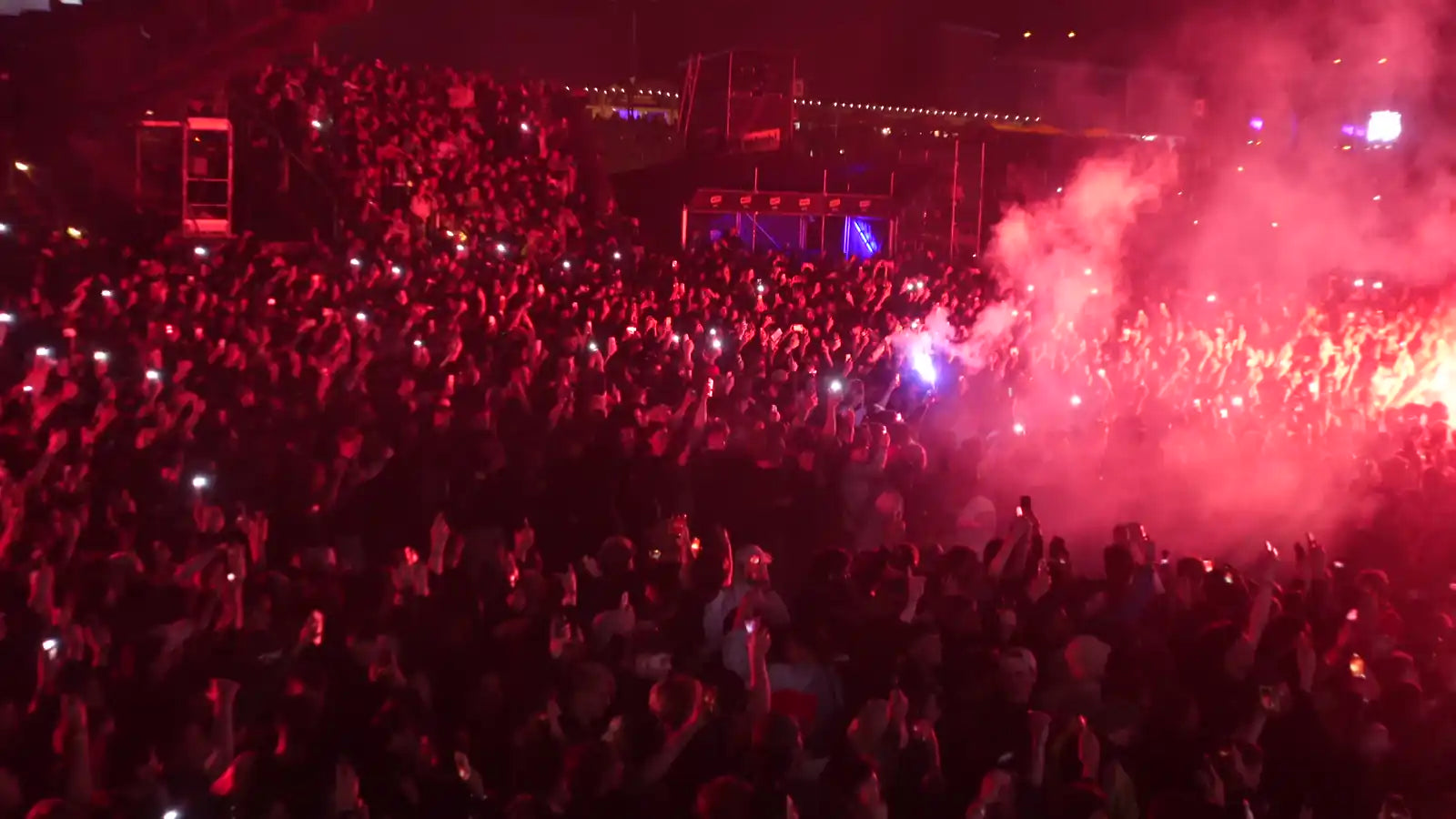 Rote Bengalos brennen nachts mitten in der Festival-Crowd